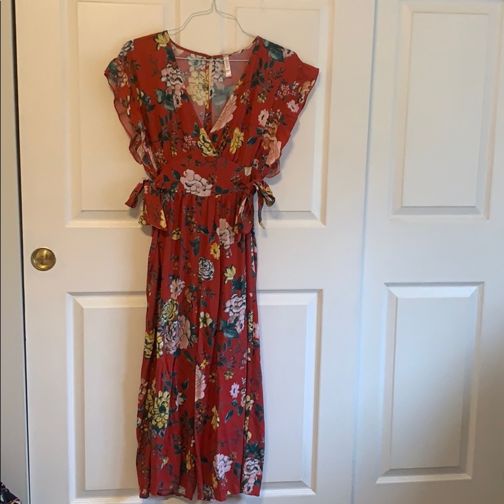 Floral jumpsuit with adjustable tie sides.